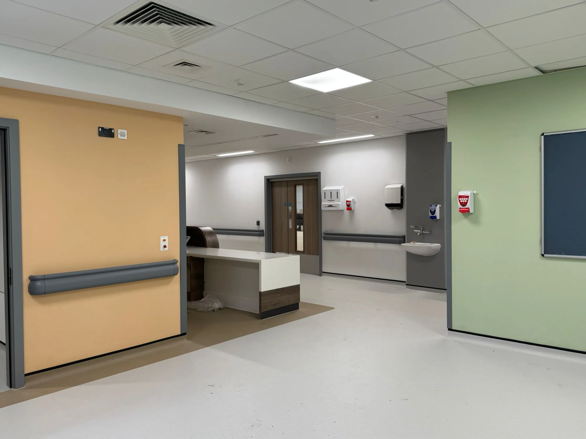 Hospital ward area with colour-coded accent walls in orange and green freshly painted